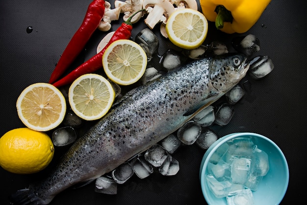 Fresh whole salmon in ice. Decorated with vegetables. 