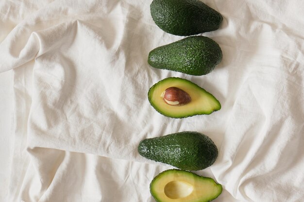 Foto frutta fresca intera e affettata dell'avodcado su fondo chiaro