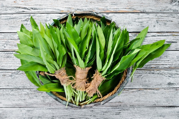 Fresh wild garlic leaves in a wooden box Wild leek Top view Free space for your text