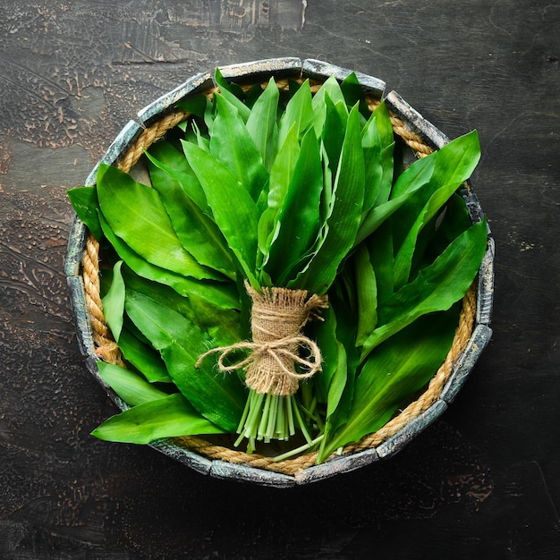 Fresh wild garlic leaves in a wooden box Wild leek Top view Free space for your text