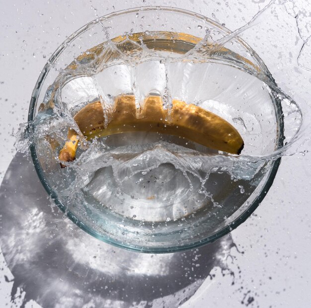 Foto banana gialla fresca in una ciotola d'acqua