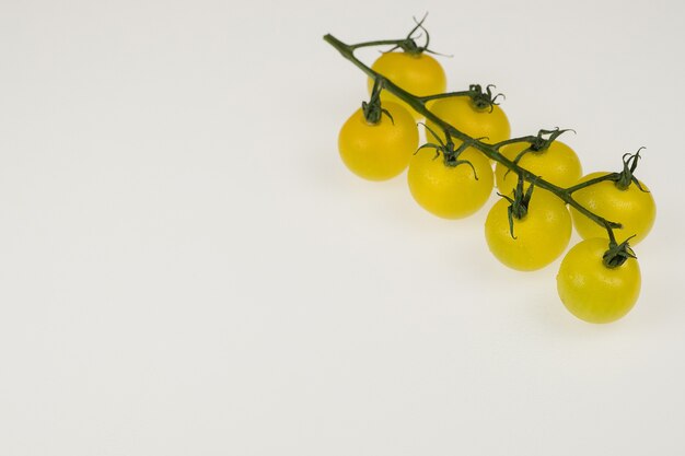 Fresh yellow cherry tomatoes on a white background. wet tomatoes