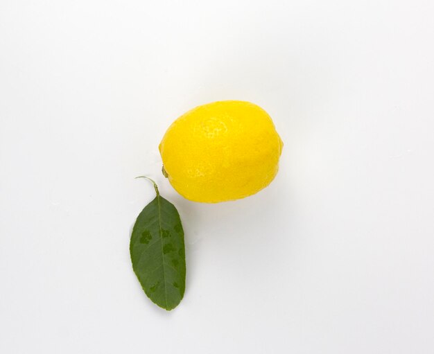 a fresh yellow lemon fruit with leaf isolated on white background used in healthy food diet concept