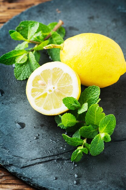 Fresh yellow lemon and green mint on the table