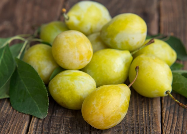 Fresh yellow plum closeup yellow plum in on a wooden table rustic background