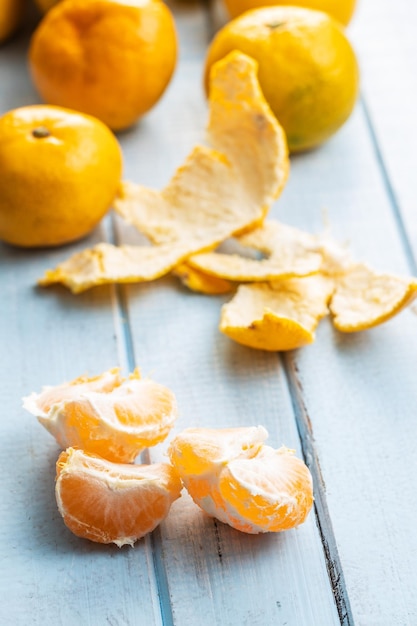 Fresh yellow tangerines on blue wooden table