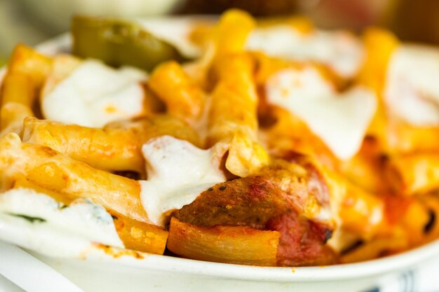 Foto pasta fresca di ziti con salsiccia nel ristorante italiano.