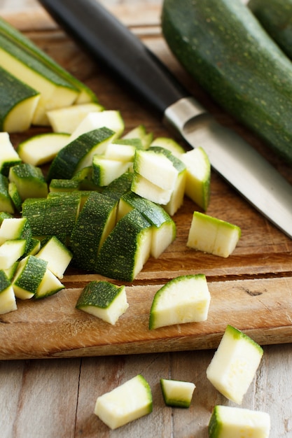 Fresh zucchini on a wooden board with a knife