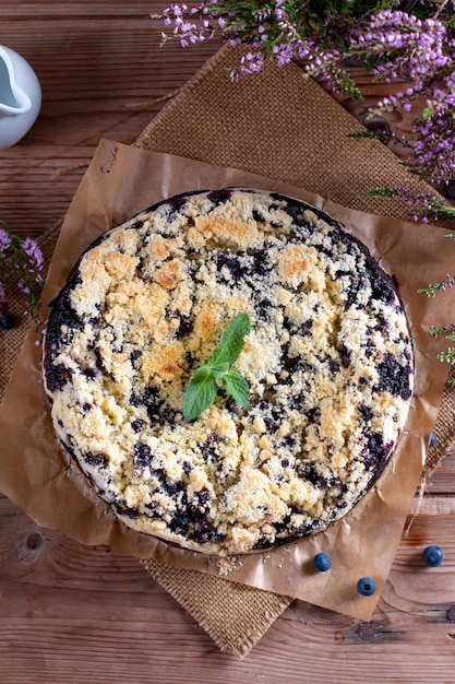 Foto torta di mirtilli appena sfornata su tavola di legno concetto di prodotti da forno