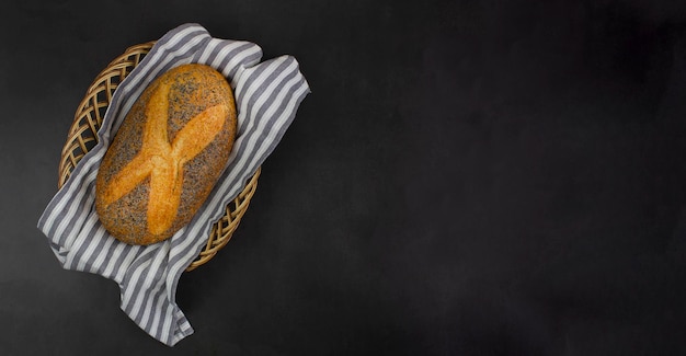 Freshly baked bread in a basket on a black background copy space