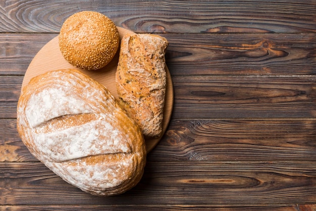 Свежеиспеченный хлеб на разделочной доске на белом деревянном фоне вид сверху хлеб с копией пространства