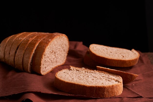 Freshly baked bread on dark wooden kitchen table. Selective focus