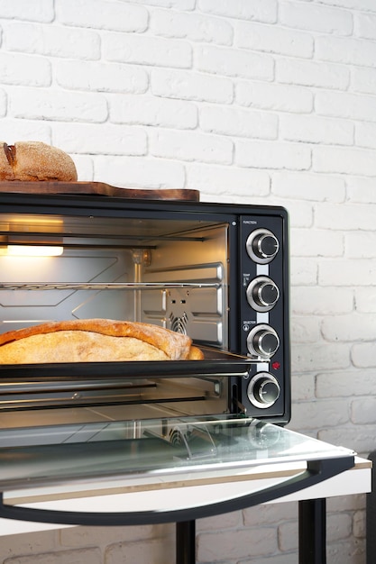 Photo freshly baked bread in mini oven in the kitchen
