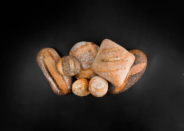 Freshly baked bread and rolls on a black background Copy space