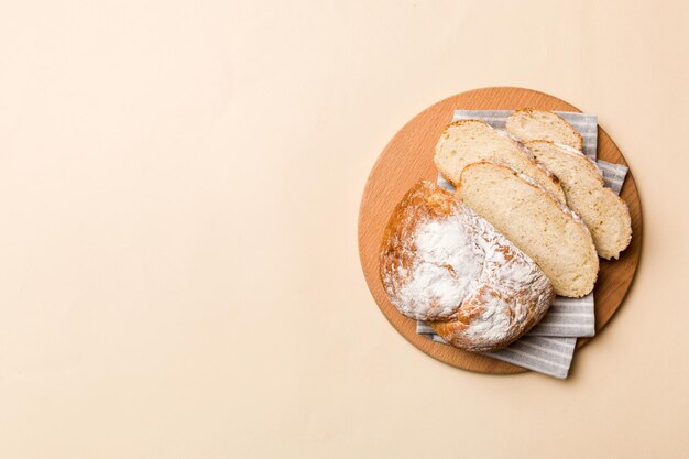 Freshly baked bread slices on cutting board against white wooden background top view Sliced bread