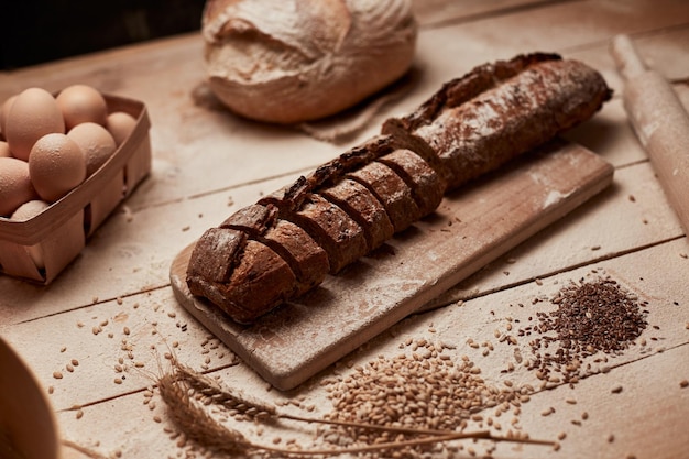 Freshly baked bread Top view of sliced wholegrain bread on dark ructic wooden background closeup