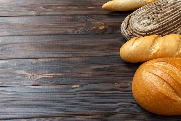 Freshly baked bread on wooden background, top view