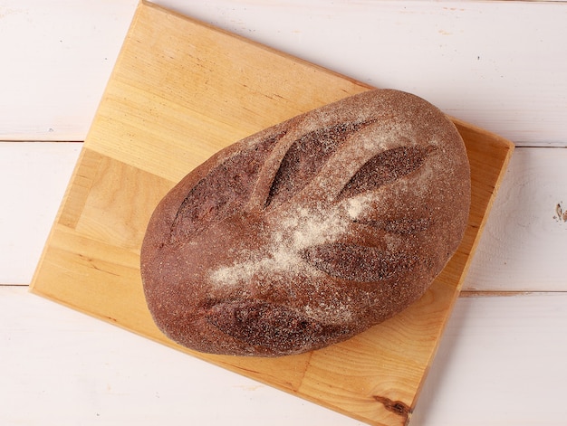 Freshly baked bread on wooden desk on white wooden kitchen table