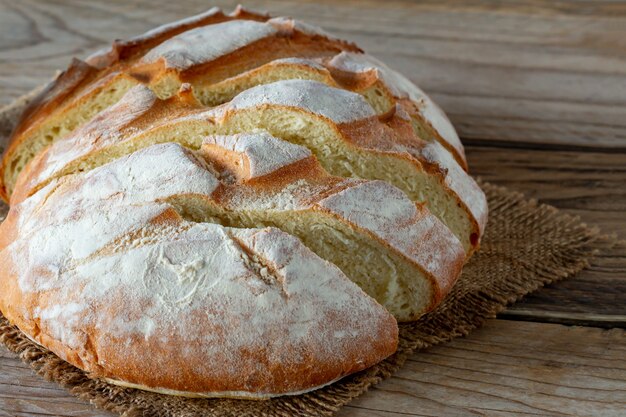 Freshly baked bread on wooden gray kitchen table, homemade pastry.