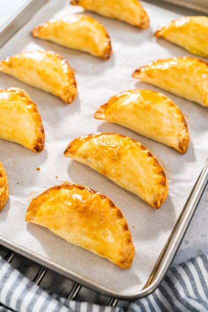 Freshly baked breakfast empanadas with eggs and sweet potato on the kitchen counter