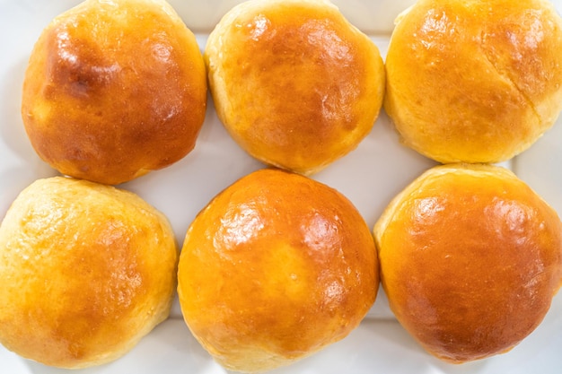 Freshly baked brioche buns on a metal serving tray