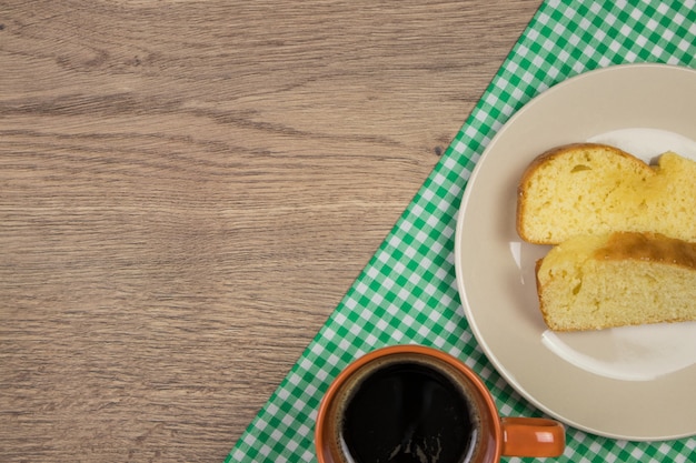 Freshly baked cake slices and green tablecloth on wooden table