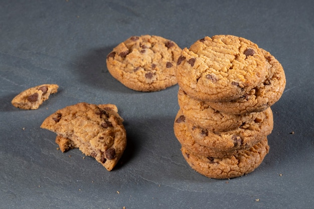 Freshly baked Chocolate chip cookies on a dark stone with place for text.