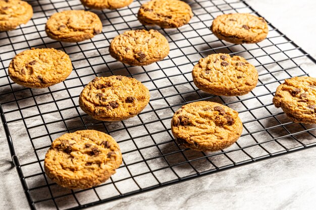 Biscotti di pepita di cioccolato appena sfornati su un ripiano di marmo.