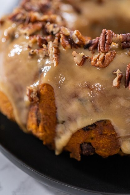 Freshly baked chocolate pumpkin bundt cake with toffee glaze topped with toasted pecans.