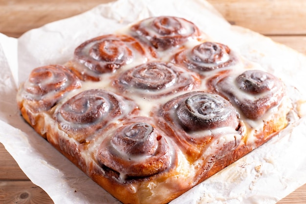 Freshly baked cinnabon buns with cream sauce on baking paper cinnabons for breakfast