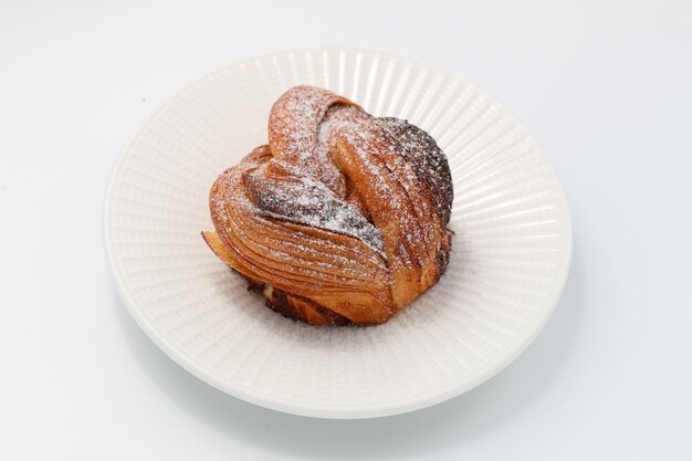 Freshly baked cinnamon bun on a white plate