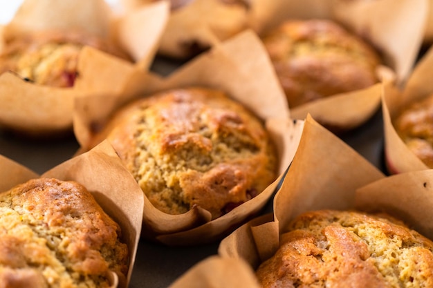 Freshly baked cranberry muffins in brown paper muffin cups.