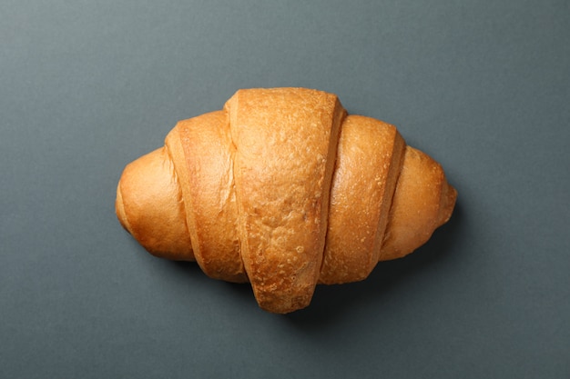 Freshly baked croissant on dark background, top view