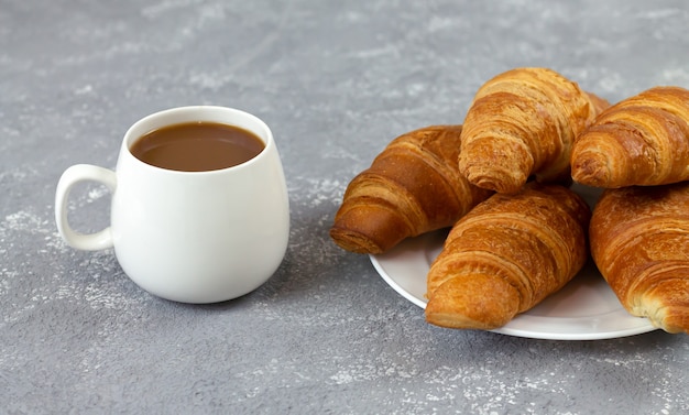 素朴な石のテーブルに焼きたてのクロワッサンと一杯のコーヒー