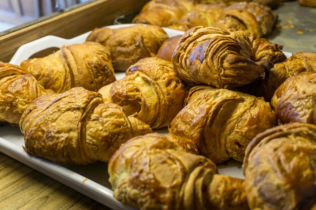 Freshly baked croissants on wooden cutting board, top view