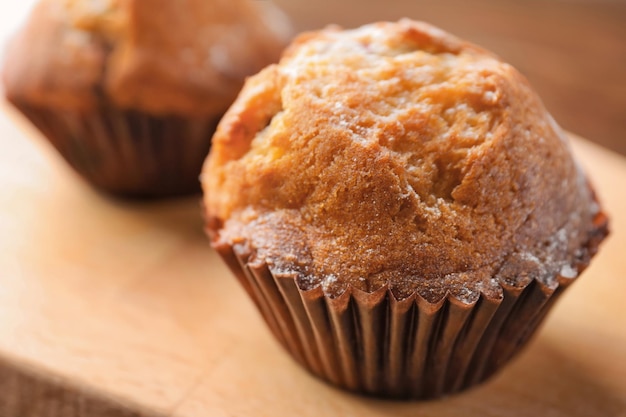 Freshly baked cupcake on wooden board closeup