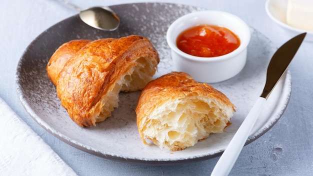 A freshly baked French Croissant butter and jam