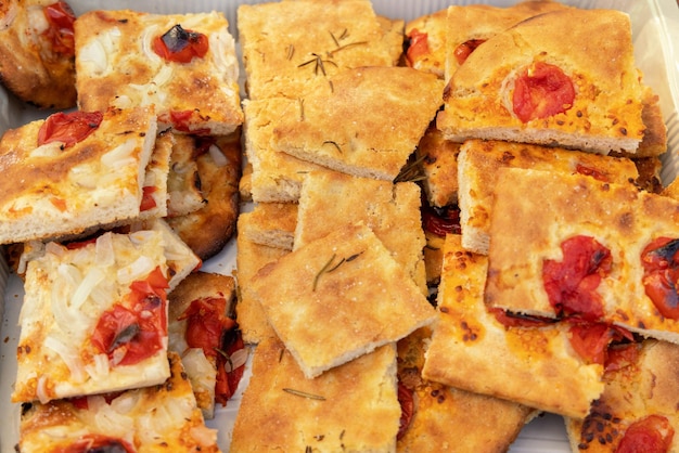 Freshly baked homemade apulian focaccia with tomatoes cut in slices top view