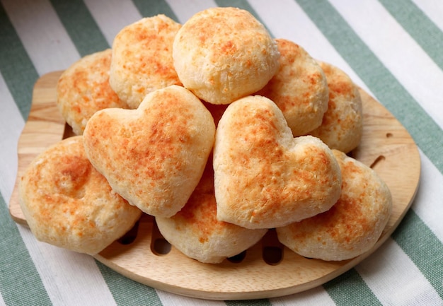 Pane al formaggio brasiliano fatto in casa appena sfornato o pao de queijo con un paio di cuori a forma di cuore sulla parte superiore