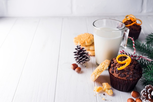 Freshly baked homemade chocolate muffins with jug with milk