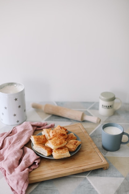 Freshly baked homemade pastry on kitchen table breakfast with puff buns and a glass of milk