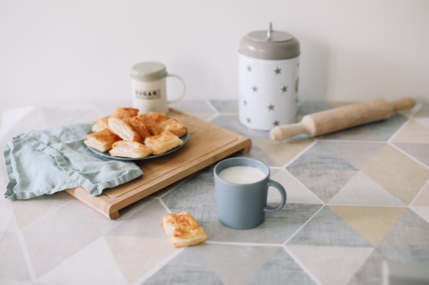 Freshly baked homemade pastry on kitchen table breakfast with puff buns and a glass of milk