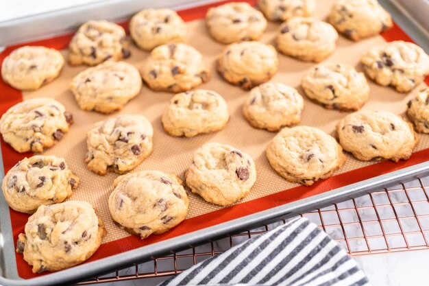 Freshly baked homemade soft chocolate chip cookies on a baking sheet.