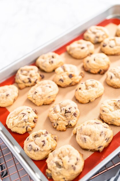 Freshly baked homemade soft chocolate chip cookies on a baking sheet.