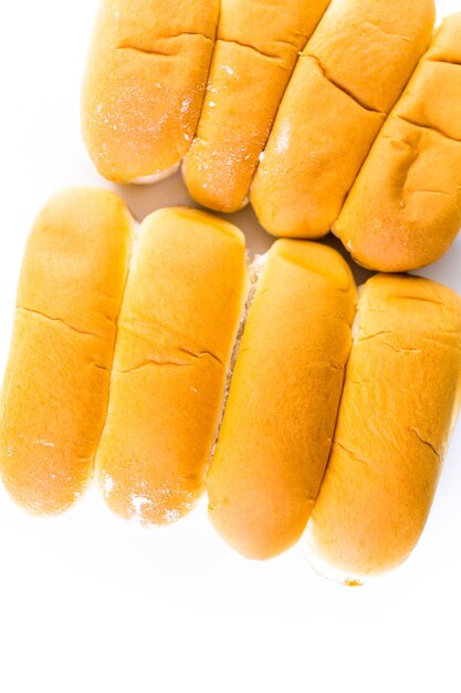 Freshly baked hot dog buns on a white background.