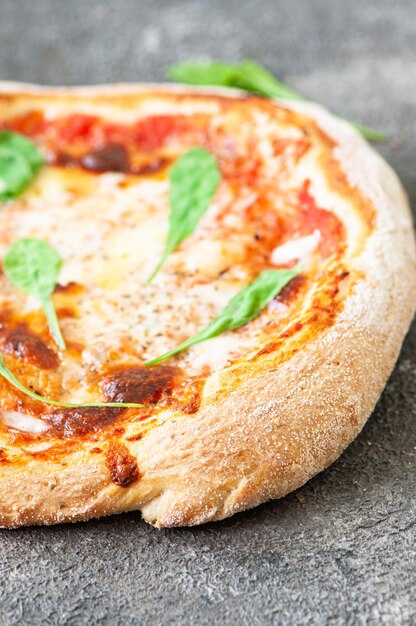 Pizza italiana appena sfornata su sfondo grigio primo piano