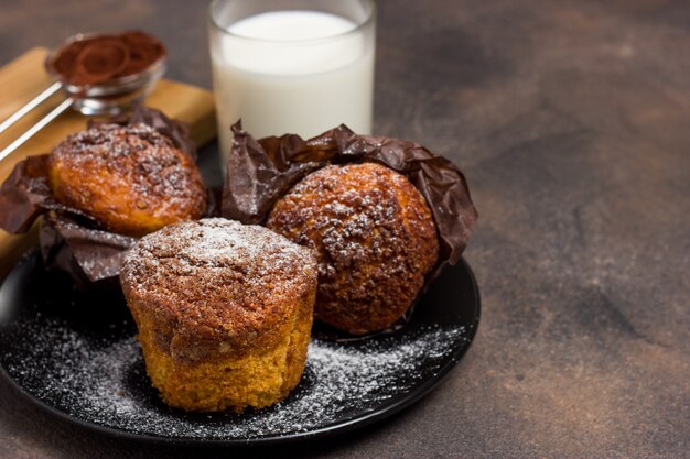 Foto muffin appena sfornati con rabbocco crumble di cacao, cannella e avena su una tavola di legno naturale