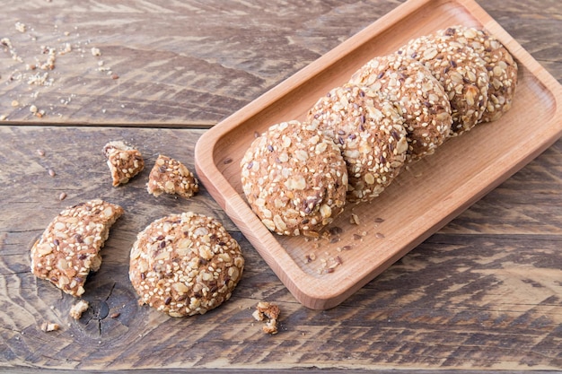 Freshly baked ovry biscuits on a wooden tray and a rustic table. the concept of healthy eating.