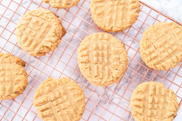 Freshly baked peanut butter cookies cooling on a drying rack.