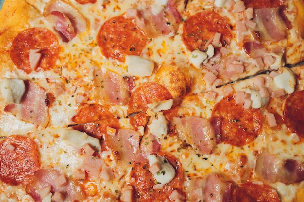 Freshly Baked Pepperoni Pizza with Tomatoes, Pepperoni and Cheese on Cutting Board closeup